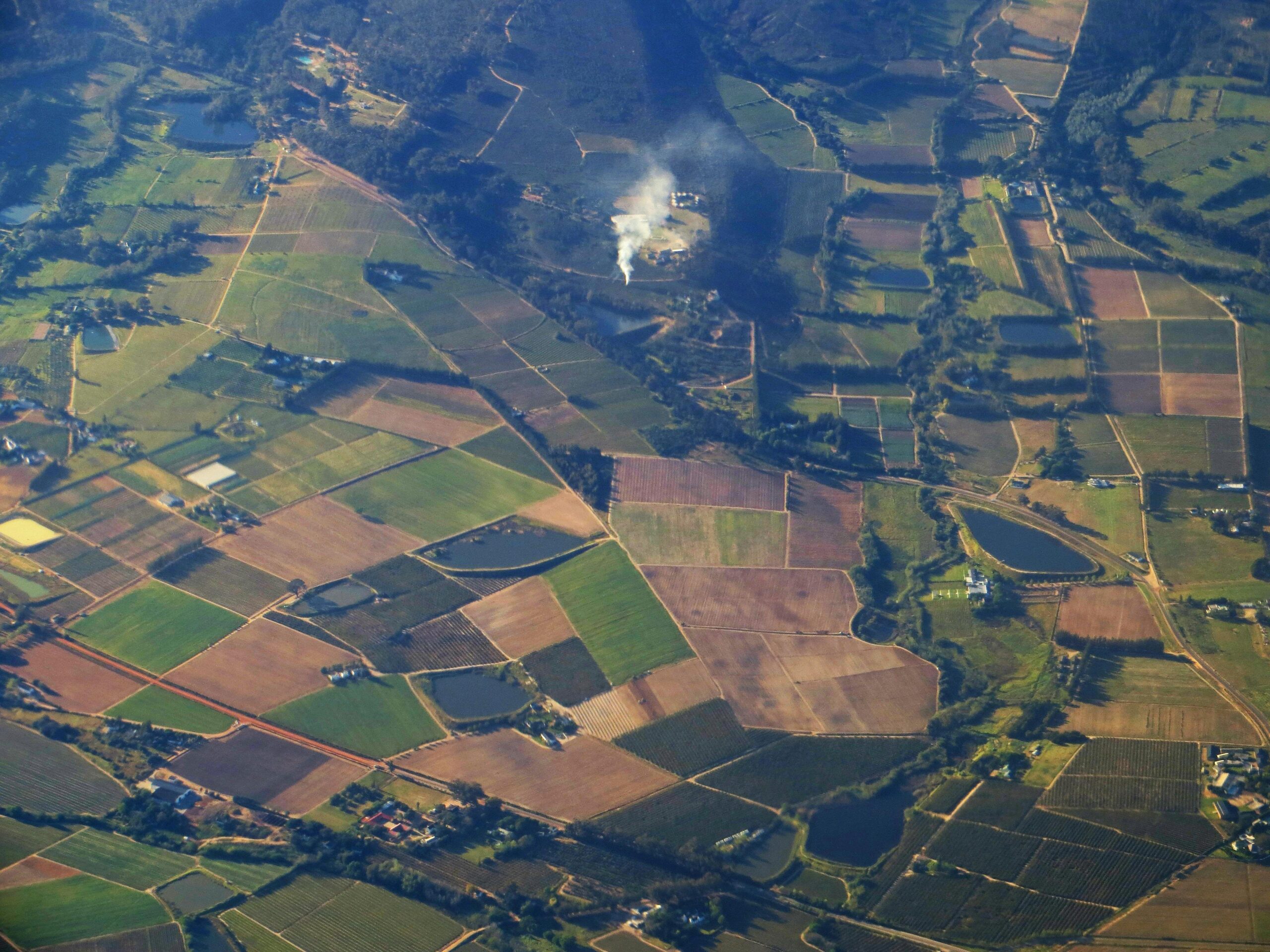 Aerial landscape of diverse farmlands and countryside near Cape Town, showcasing agricultural patterns.